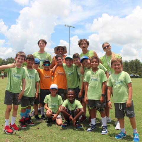 Group of male campers with counselor posing on the field