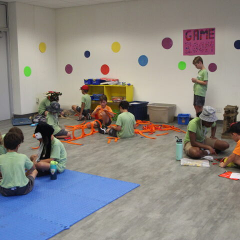 Campers playing games on the floor with counselors