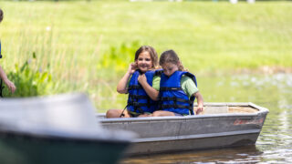 Two Pine Tree campers enjoy a canoe on the lake.