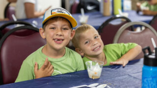 Two campers sit and eat snacks at Lynn's Pine Tree Camps.