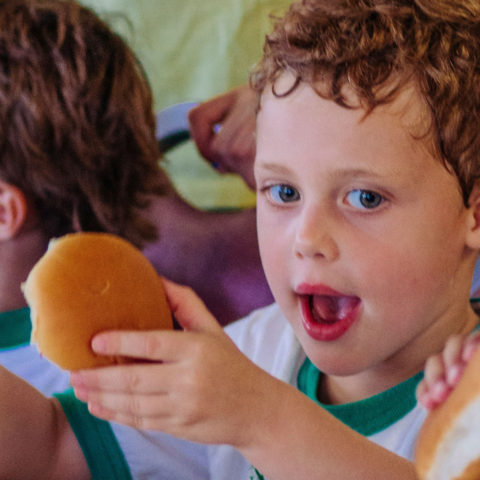 Little boy eating a burger