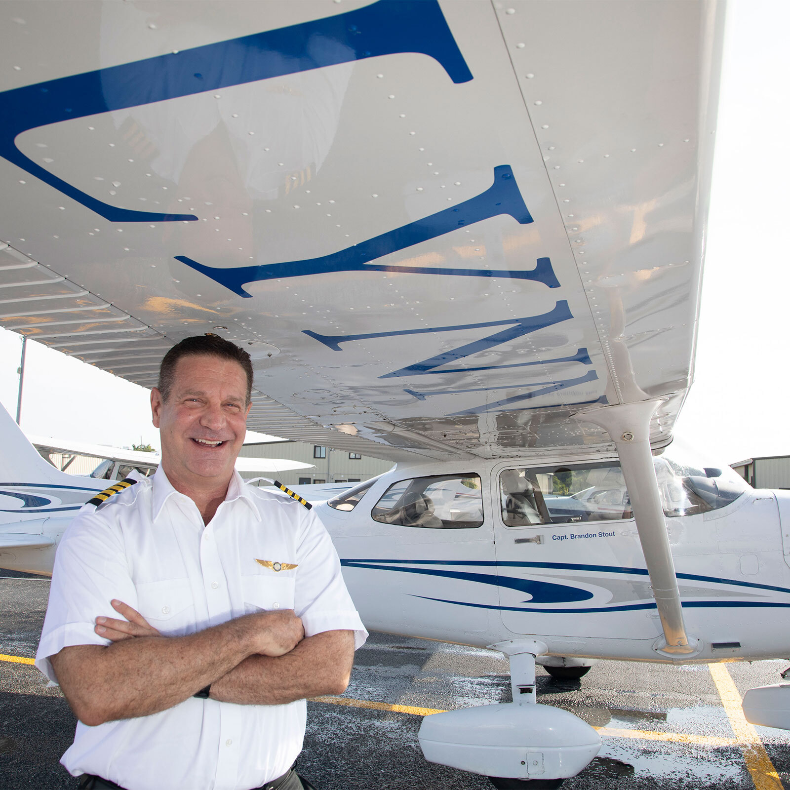 David Cohen, dean of the College of Aeronautics, smiles underneath one of Lynn University's airplanes.